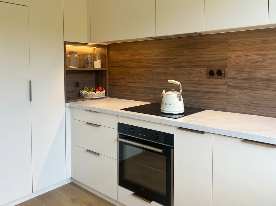 Photographie d'un petit espace réaménagé de manière optimale : une alcôve, un placard ou un renfoncement mural transformé par Into The Wood en rangement modulaire sur mesure. L'image doit montrer des étagères réglables, des tiroirs coulissants à sortie totale, et un système d'organisation vertical intelligent exploitant chaque centimètre disponible. Finitions en bois naturel ou laqué, quincaillerie Blum visible, éclairage LED discret intégré. L'aménagement doit démontrer clairement comment un espace contraint a été maximisé et fonctionnalisé. Photo prise légèrement en contre-plongée mettant en valeur l'ingéniosité de la conception et la précision de la fabrication artisanale. Environnement neutre, bien éclairé, valorisant le travail de menuiserie.